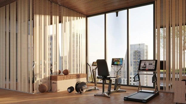 Bright modern home gym with treadmills and a stationary bike by large windows overlooking a cityscape.