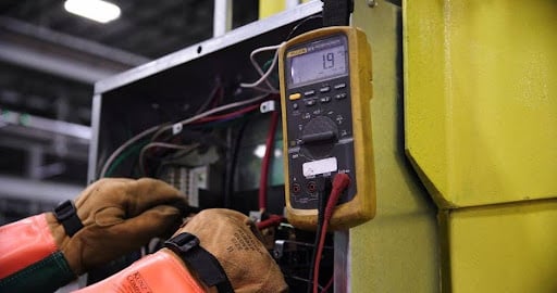 How Does PAT Testing Training Create a Qualified Engineer Career Path in 2026? A qualified engineer conducting portable appliance testing on electrical equipment