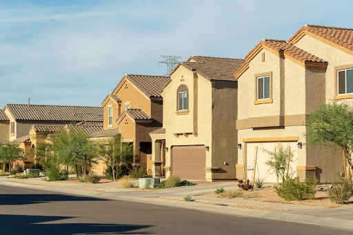 Affordable Section 8 Housing with Immediate Move-In Availability Row of beige, stucco two-story houses with tiled roofs along a residential street, desert landscaping and a clear blue sky.