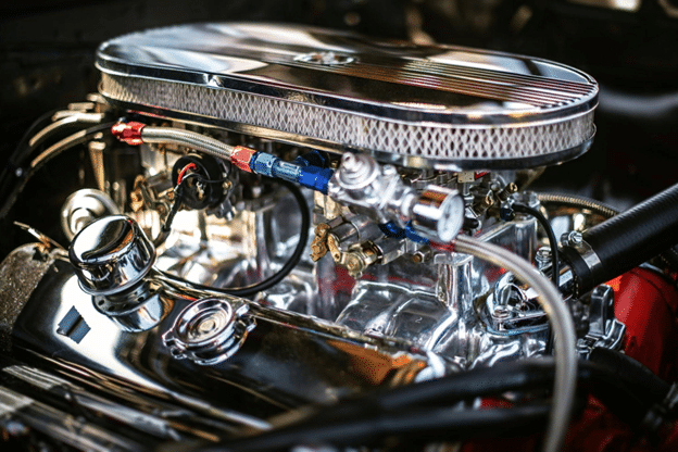 Why Your Car’s Thermostat Is More Important Than You Think Close-up of a shiny car engine with a chrome air cleaner and polished metal components, showing hoses and fittings.",