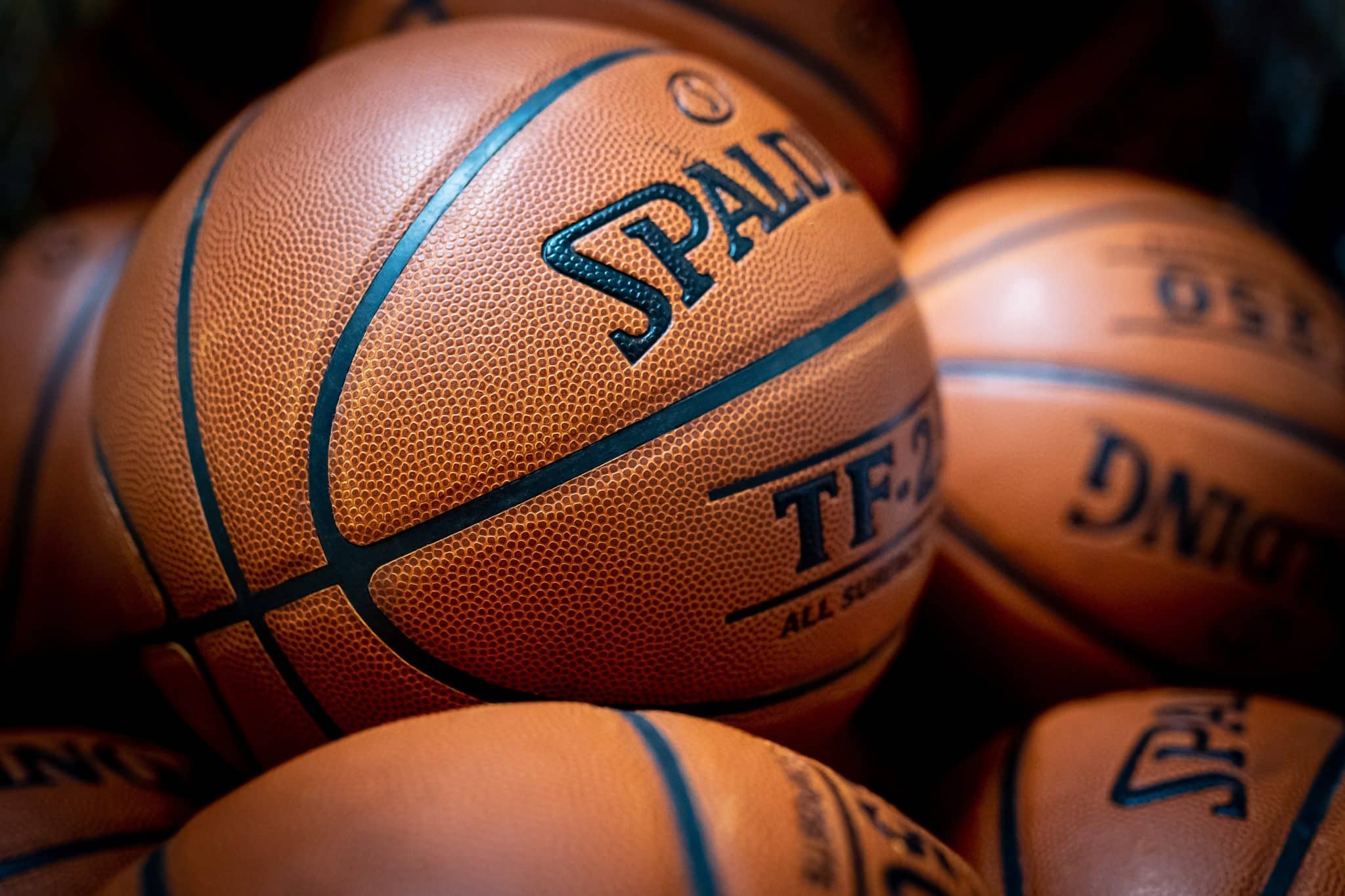 Close-up of an orange basketball with blue seams and pebbled texture.